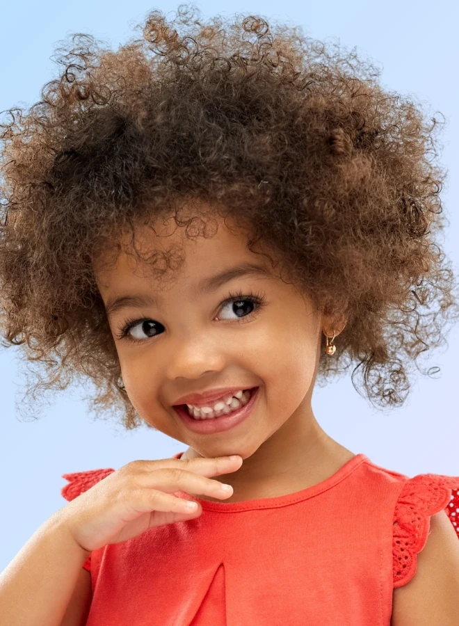 Menina sorrindo mostrando o brinco