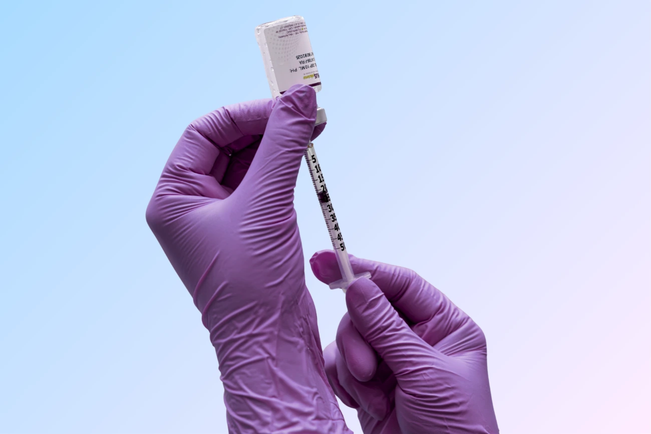 Profissional preparando medicamento com luvas